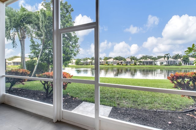 unfurnished sunroom featuring a water view