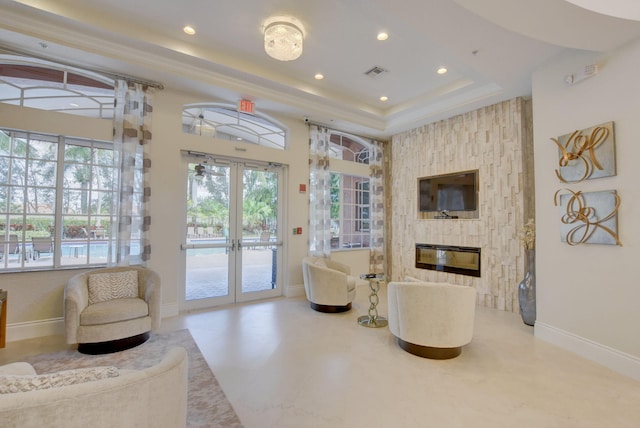 living room with a fireplace, french doors, and a raised ceiling