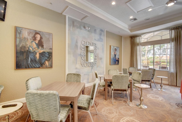 dining area featuring a textured ceiling, crown molding, and a tray ceiling