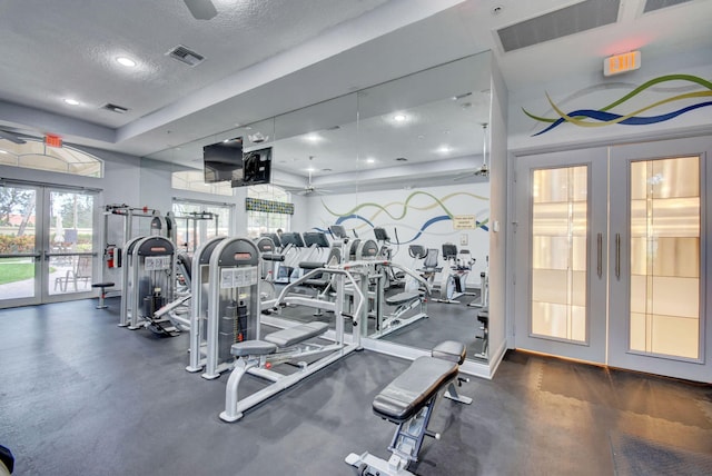 exercise room featuring ceiling fan, a textured ceiling, and french doors