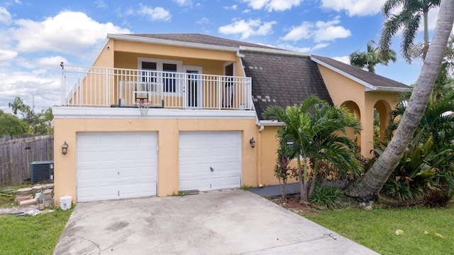 view of front of home featuring central AC, a balcony, and a garage