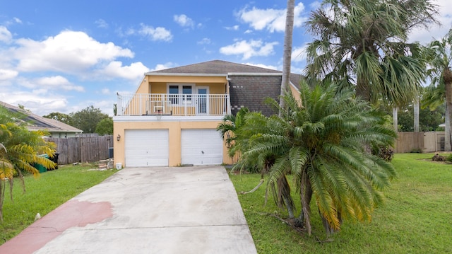 view of front of house with a balcony, a front lawn, and a garage