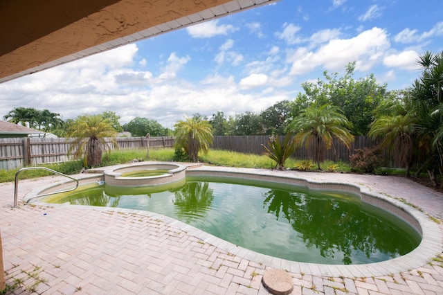 view of pool with a patio area and an in ground hot tub