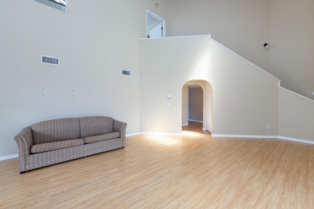 living area featuring light hardwood / wood-style flooring and a high ceiling