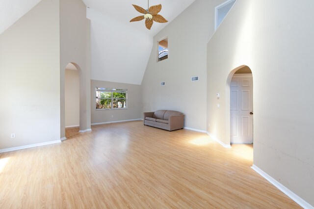 unfurnished living room with light hardwood / wood-style floors, high vaulted ceiling, and ceiling fan