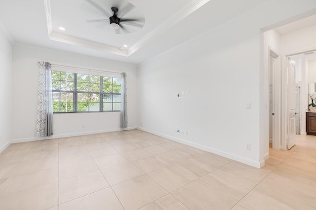 tiled empty room featuring crown molding, a tray ceiling, and ceiling fan