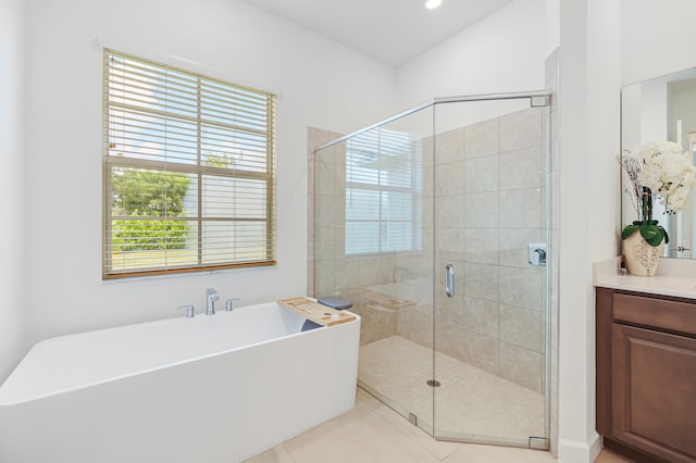 bathroom with tile patterned flooring, vanity, and plus walk in shower