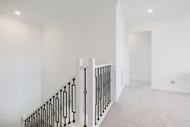 corridor with ornamental molding and light colored carpet