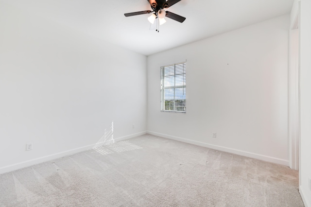 spare room with ceiling fan and light colored carpet