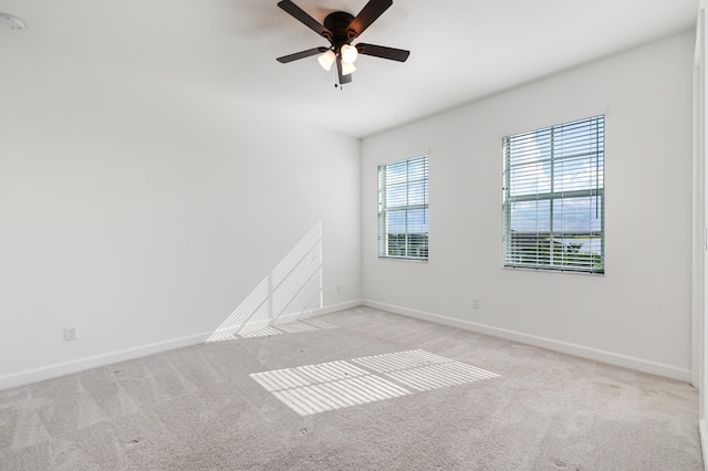 spare room with ceiling fan and light carpet