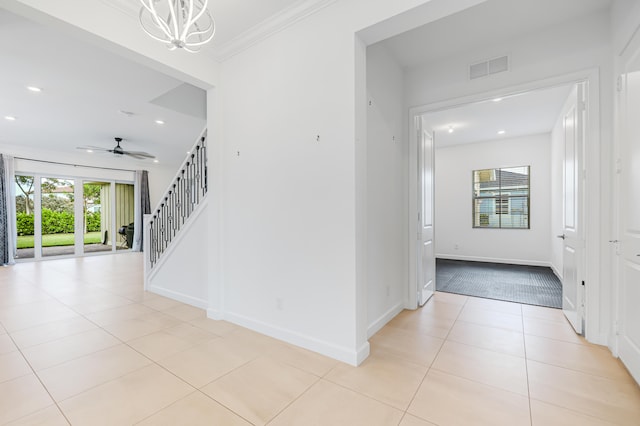 corridor featuring ornamental molding, light tile patterned floors, and a chandelier