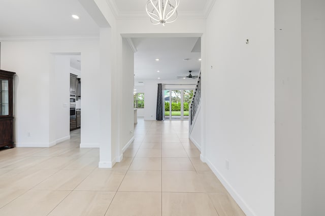 hall featuring ornamental molding, a notable chandelier, and light tile patterned floors