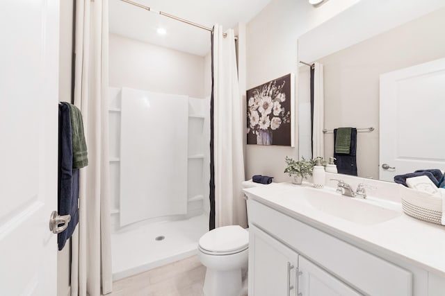 bathroom with walk in shower, vanity, and toilet