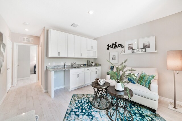 living room featuring light hardwood / wood-style floors and sink