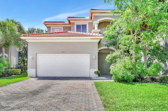 mediterranean / spanish home with a garage and a front lawn