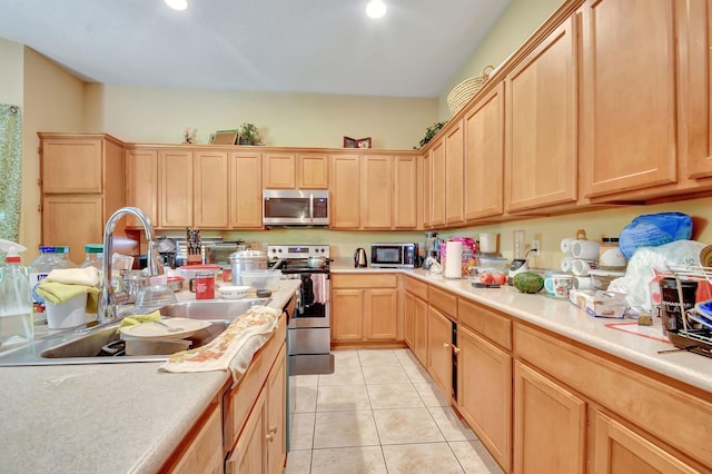 kitchen featuring stainless steel appliances, light brown cabinetry, light tile patterned floors, and sink