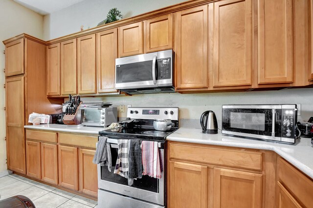 kitchen with light countertops, light tile patterned flooring, and stainless steel appliances