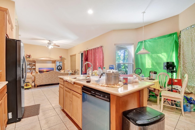 kitchen with appliances with stainless steel finishes, light tile patterned floors, ceiling fan, decorative light fixtures, and a center island with sink