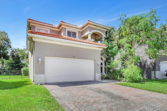 mediterranean / spanish house featuring a garage and a front lawn