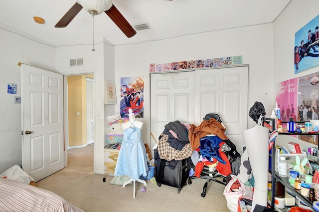 bedroom with ceiling fan, light colored carpet, and a closet