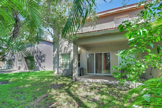 back of property featuring a patio area and a yard