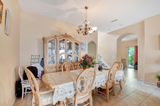 tiled dining room featuring a chandelier