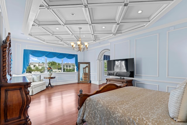 bedroom featuring ornamental molding, coffered ceiling, a notable chandelier, and wood-type flooring