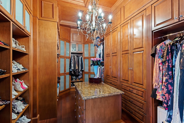 spacious closet featuring a notable chandelier and dark wood-type flooring