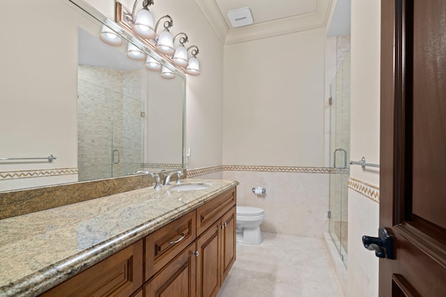 bathroom with a shower with door, toilet, vanity, crown molding, and tile walls