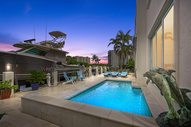 pool at dusk with a patio