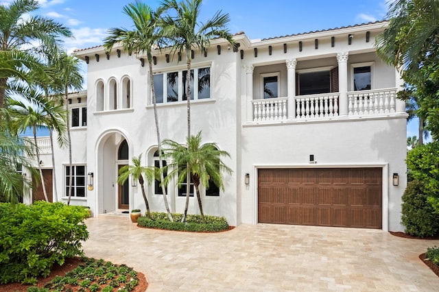 mediterranean / spanish house featuring a balcony and a garage