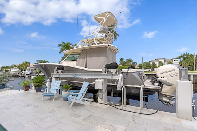 view of patio with a water view and a boat dock