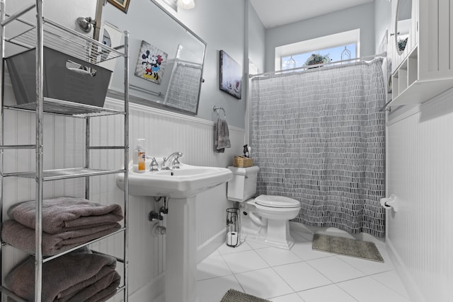 bathroom with curtained shower, tile patterned flooring, and toilet