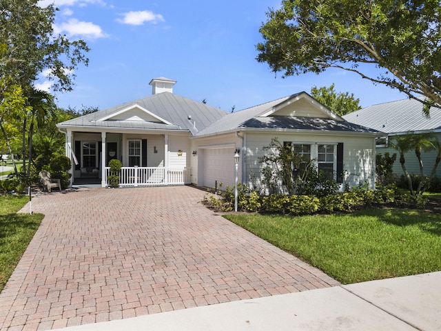 single story home with a front yard, a garage, and covered porch