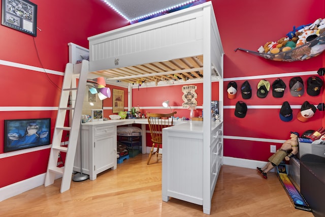 bedroom featuring light wood-type flooring and built in desk