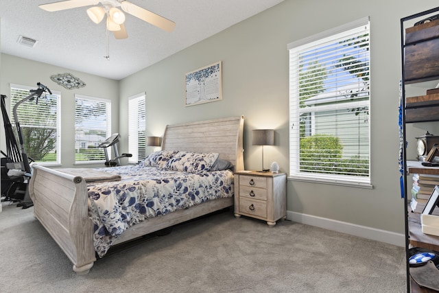 carpeted bedroom featuring a textured ceiling and ceiling fan