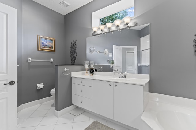 bathroom featuring a bathtub, vanity, a textured ceiling, tile patterned flooring, and toilet