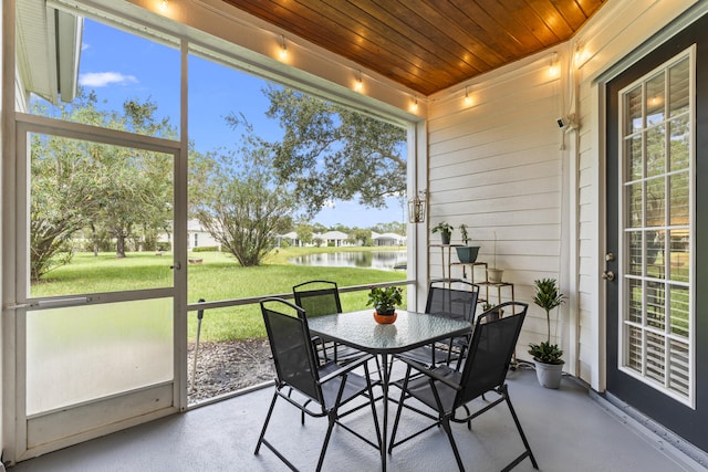 sunroom featuring wood ceiling and a water view