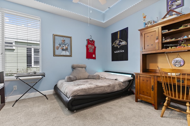 bedroom featuring light carpet, multiple windows, and ceiling fan