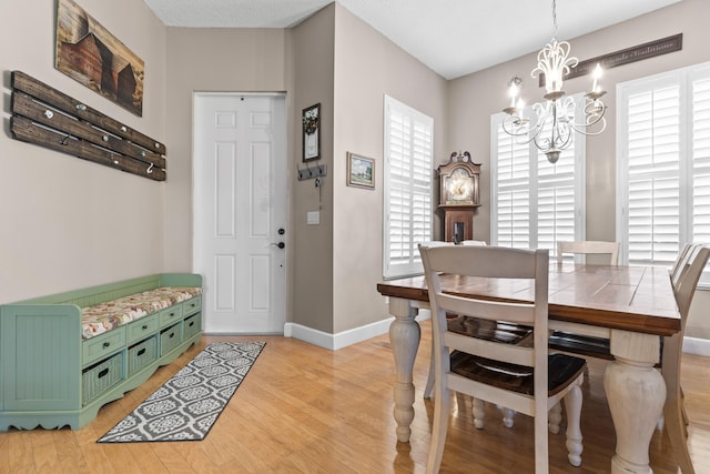 dining area featuring a textured ceiling, an inviting chandelier, light hardwood / wood-style flooring, and a wealth of natural light