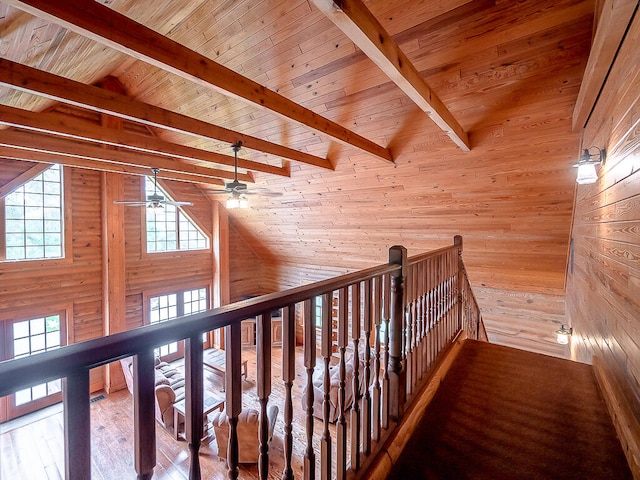 hall with wood-type flooring, wood ceiling, wood walls, and lofted ceiling with beams