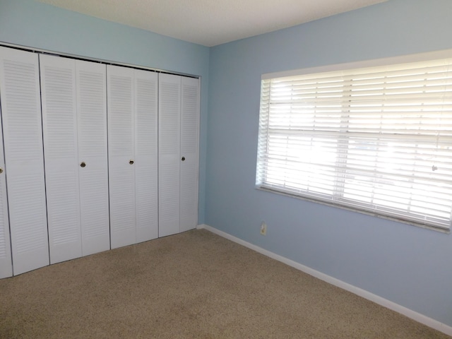 unfurnished bedroom with carpet and a closet