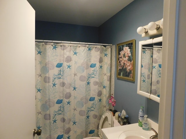 bathroom with toilet, curtained shower, and vanity