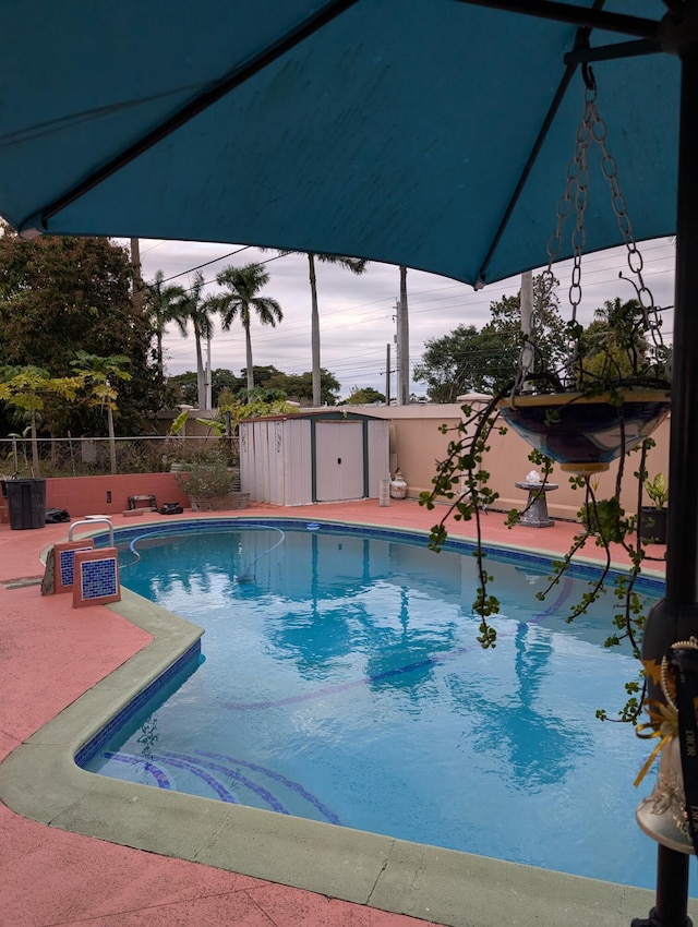 pool at dusk featuring a storage shed