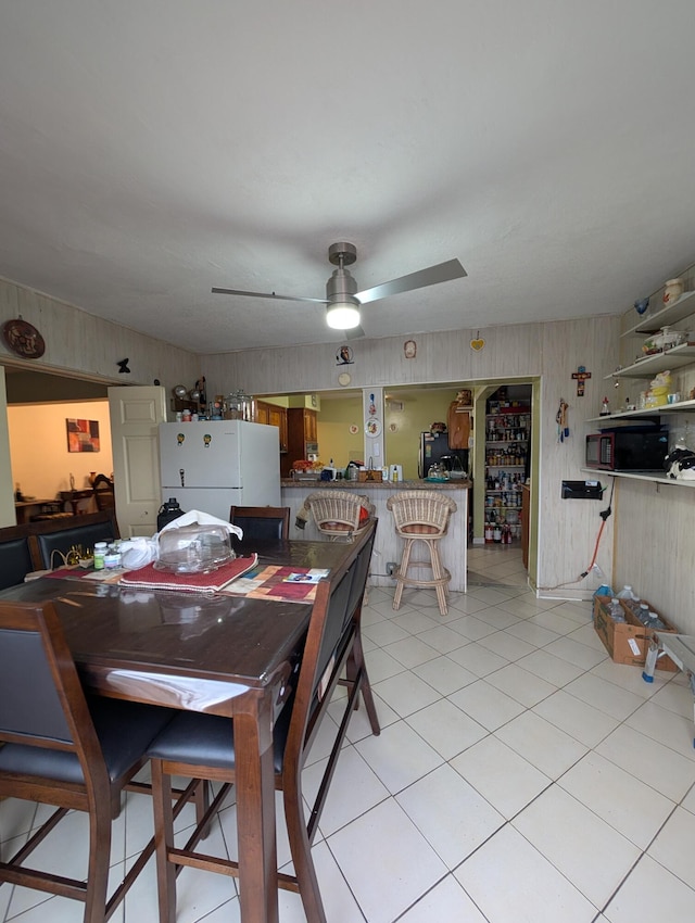 tiled dining space featuring ceiling fan