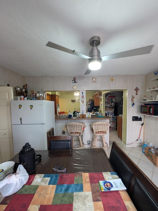 dining area with light tile patterned floors and ceiling fan