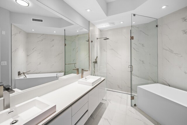 3100 N Ocean Dr Unit H-1508, Singer Island, FL 33404 - full bathroom with marble tiled flooring, double vanity, a freestanding bath, a marble finish shower, and recessed lighting