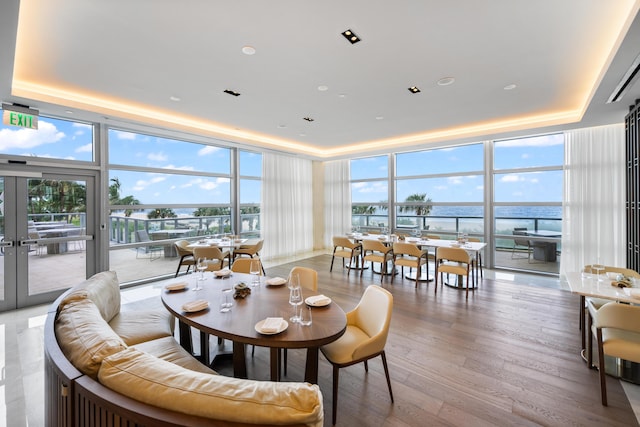 3100 N Ocean Dr Unit H-1508, Singer Island, FL 33404 - dining space with a wall of windows, a raised ceiling, healthy amount of natural light, and wood finished floors
