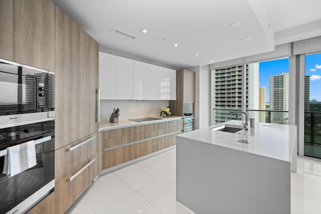 3100 N Ocean Dr Unit H-1508, Singer Island, FL 33404 - kitchen with black oven, modern cabinets, a sink, stainless steel microwave, and recessed lighting