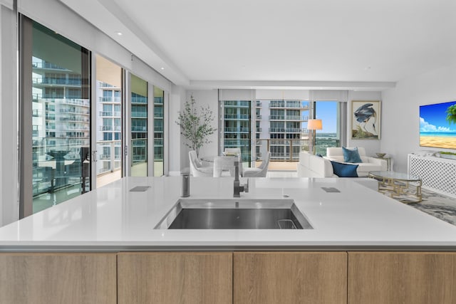 3100 N Ocean Dr Unit H-1508, Singer Island, FL 33404 - kitchen featuring open floor plan, light countertops, a sink, and an island with sink